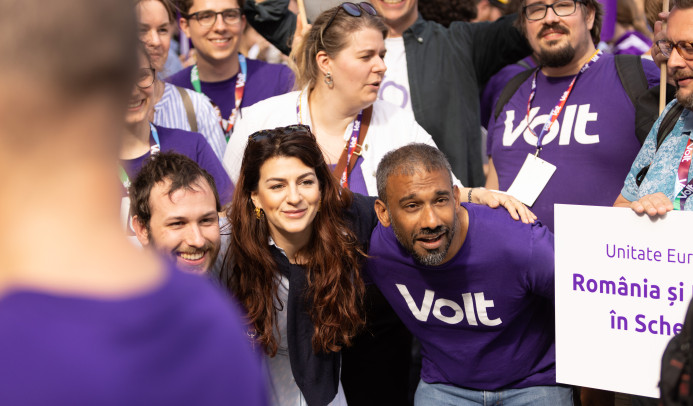 Women and men wearing Volt t-shirts pose for a picture in the streets of Bucharest