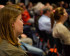 Photo of people sitting on chairs in rows and listening to a presentation