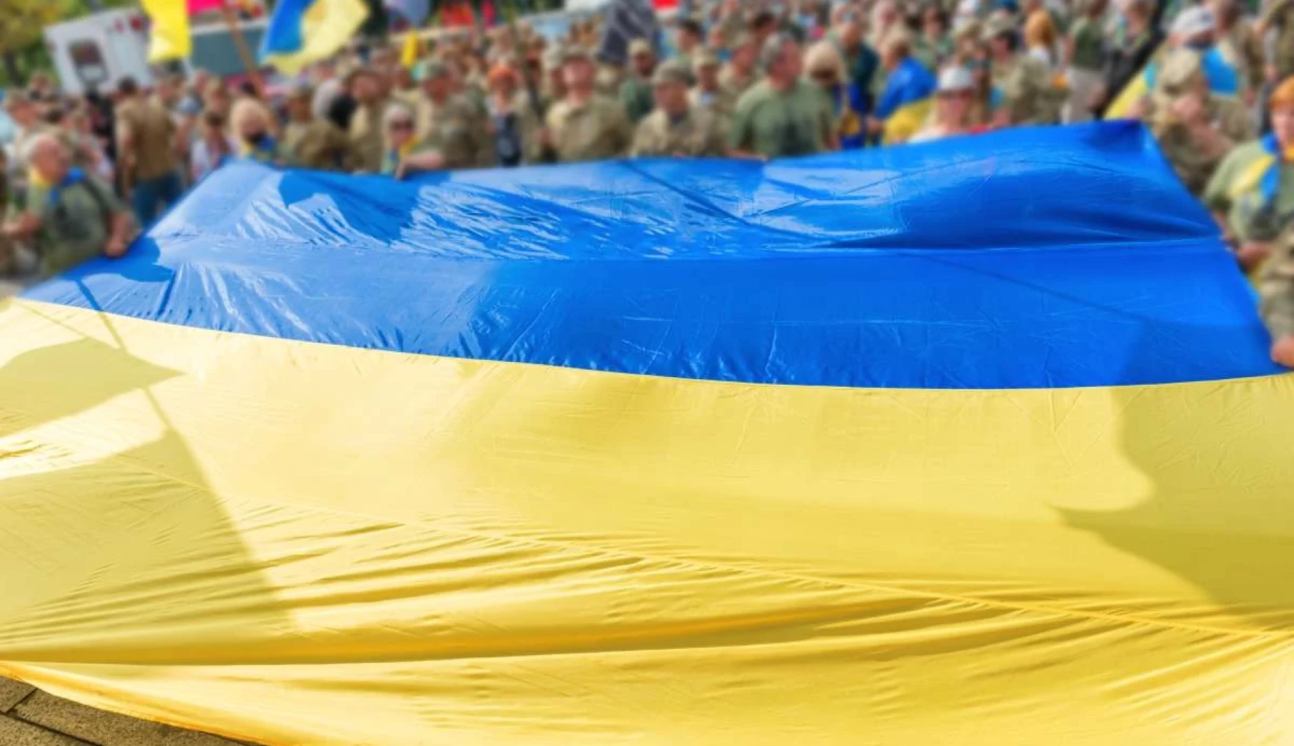 The Ukrainian flag in the foreground, with a group of people in the background