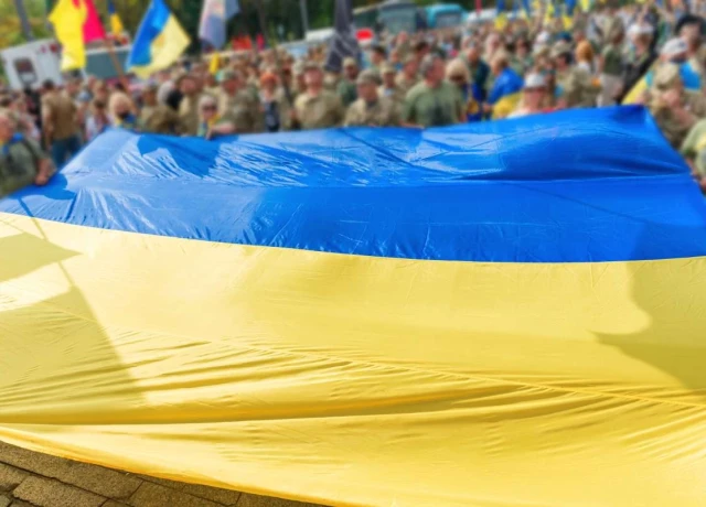 The Ukrainian flag in the foreground, with a group of people in the background
