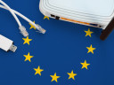 A flag of the European Union with on top of that a router, two ethernet cables, and a dongle.