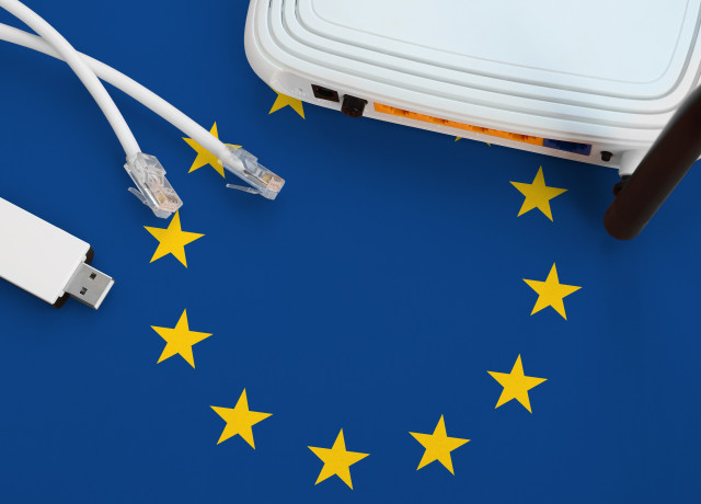 A flag of the European Union with on top of that a router, two ethernet cables, and a dongle.