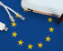 A flag of the European Union with on top of that a router, two ethernet cables, and a dongle.