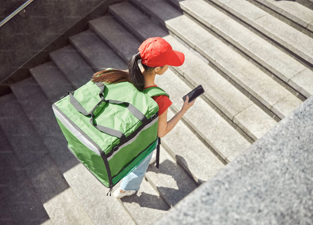 female delivery person walking upwardss on a stairway