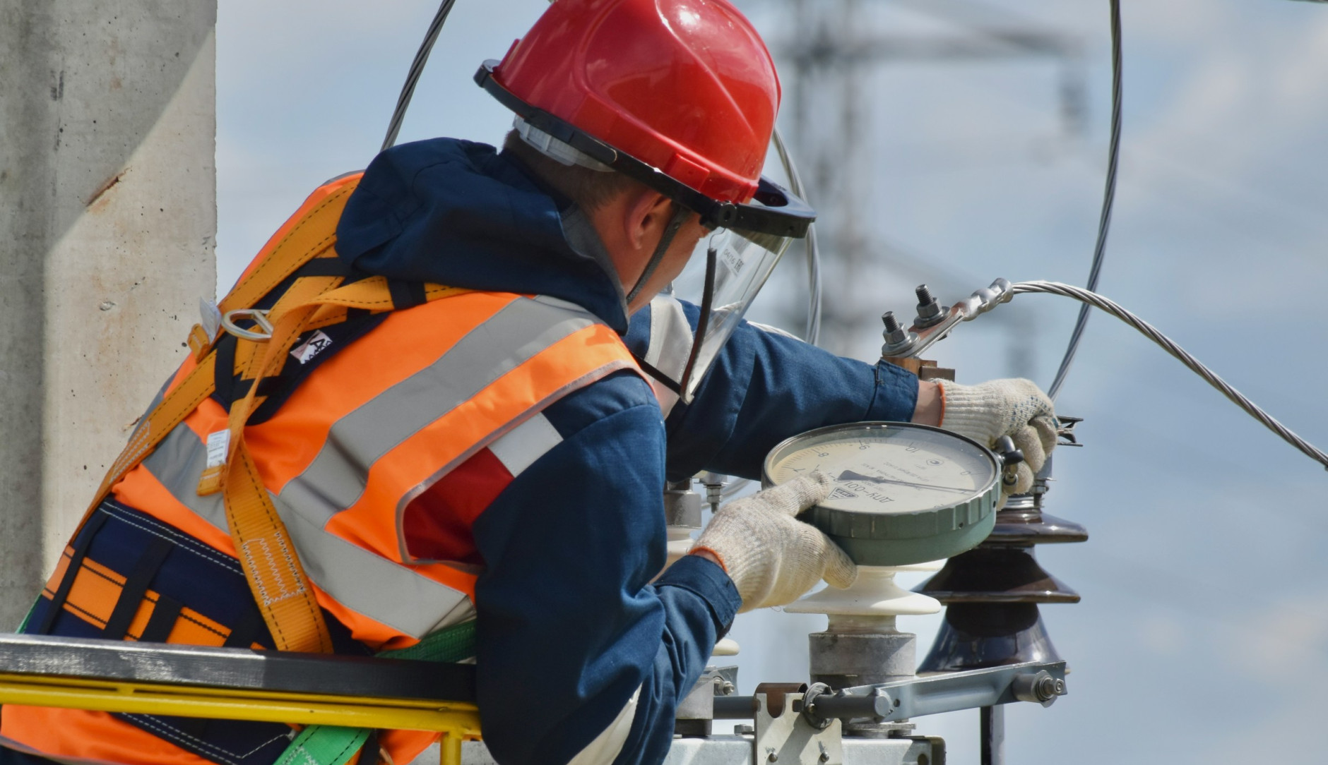 Man with orange vest working on electric cables