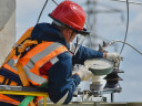 Man with orange vest working on electric cables