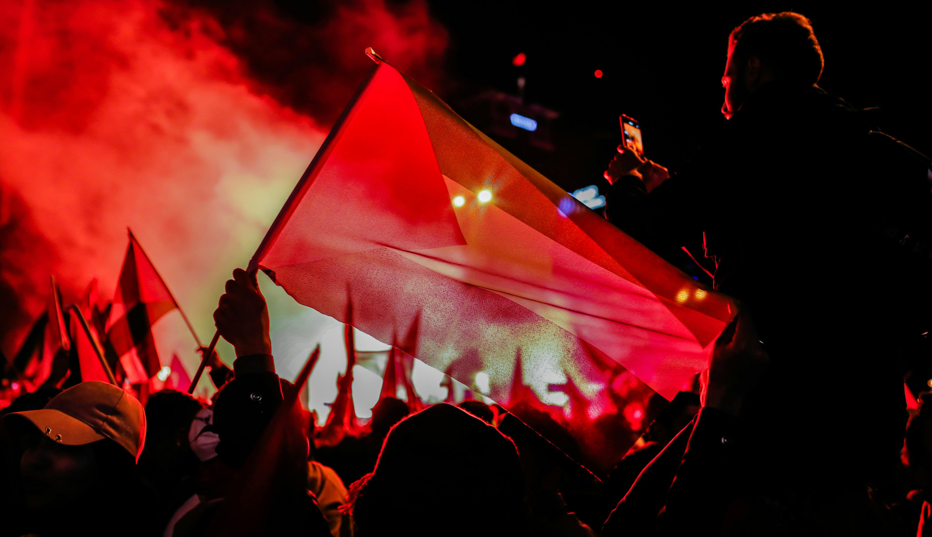 People with a Palestinian flag celebrating at night