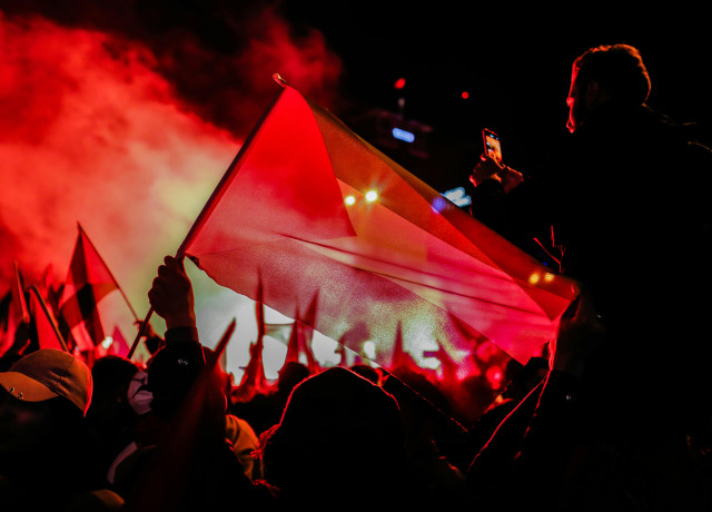 People with a Palestinian flag celebrating at night