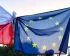 Polish and European Union flag tied together and raised in the air.
