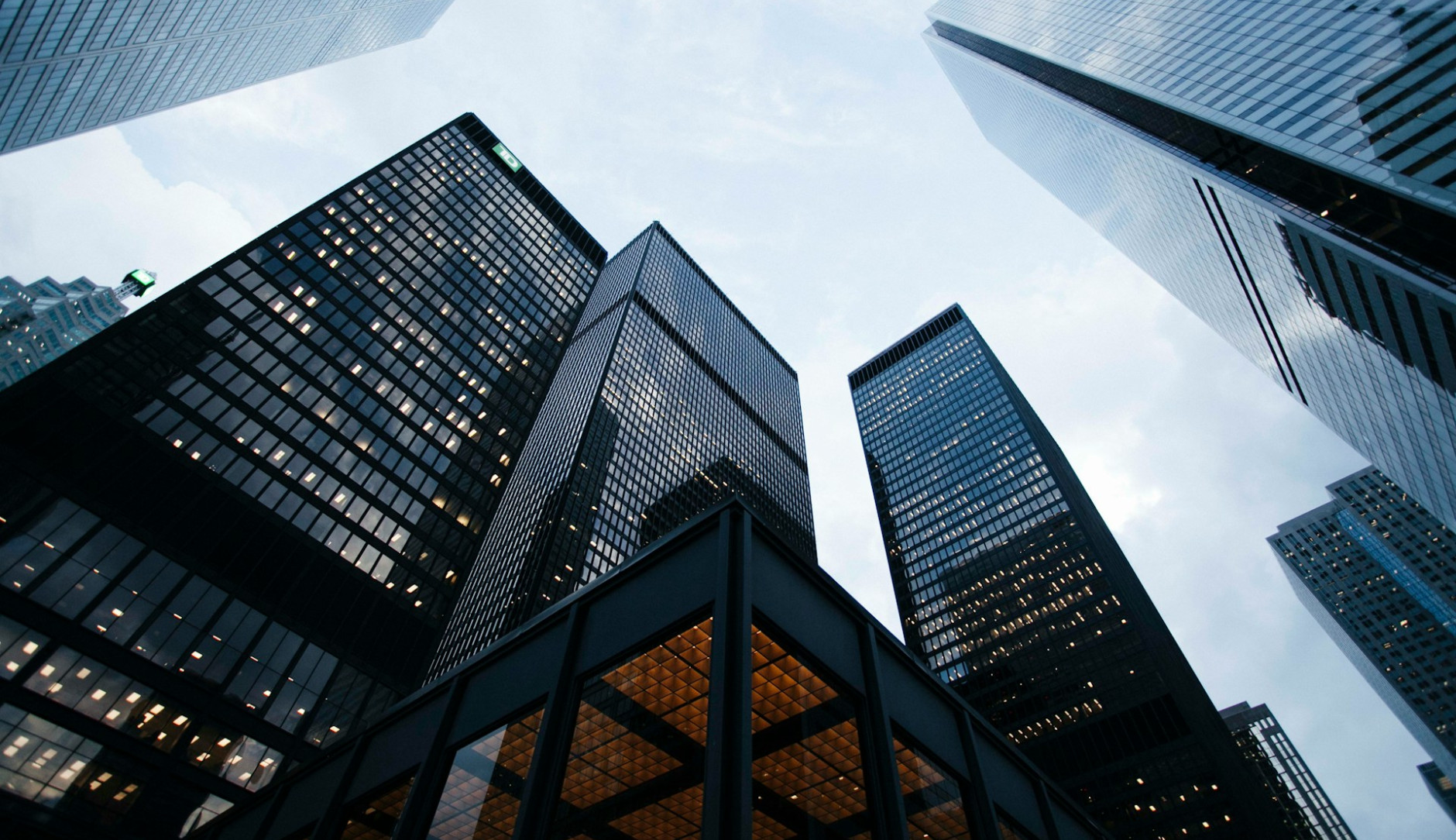 Photo of several high.rise buildings taken from below and looking at the sky