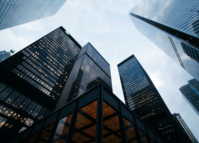 Photo of several high.rise buildings taken from below and looking at the sky