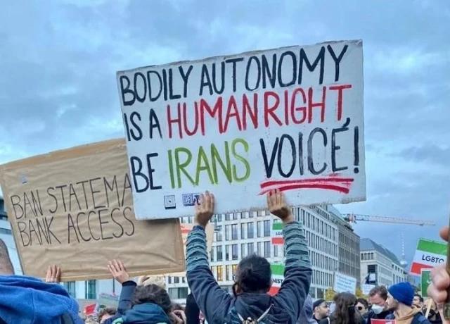 Protestors with a sign that reads, 'Bodily Autonomy is a human right, be Iran's Voice'
