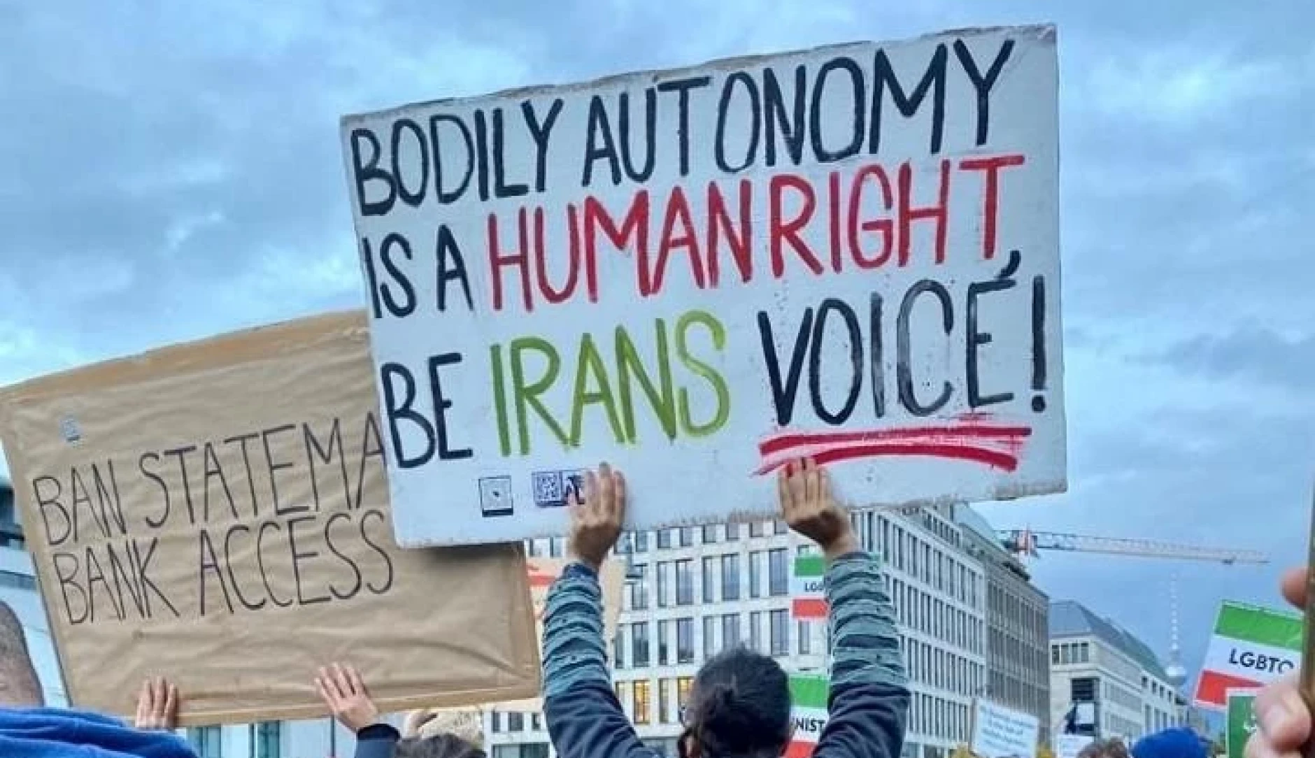 Protestors with a sign that reads, 'Bodily Autonomy is a human right, be Iran's Voice'