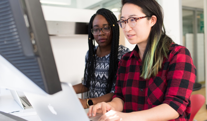 Two women of colour are working together on a laptop